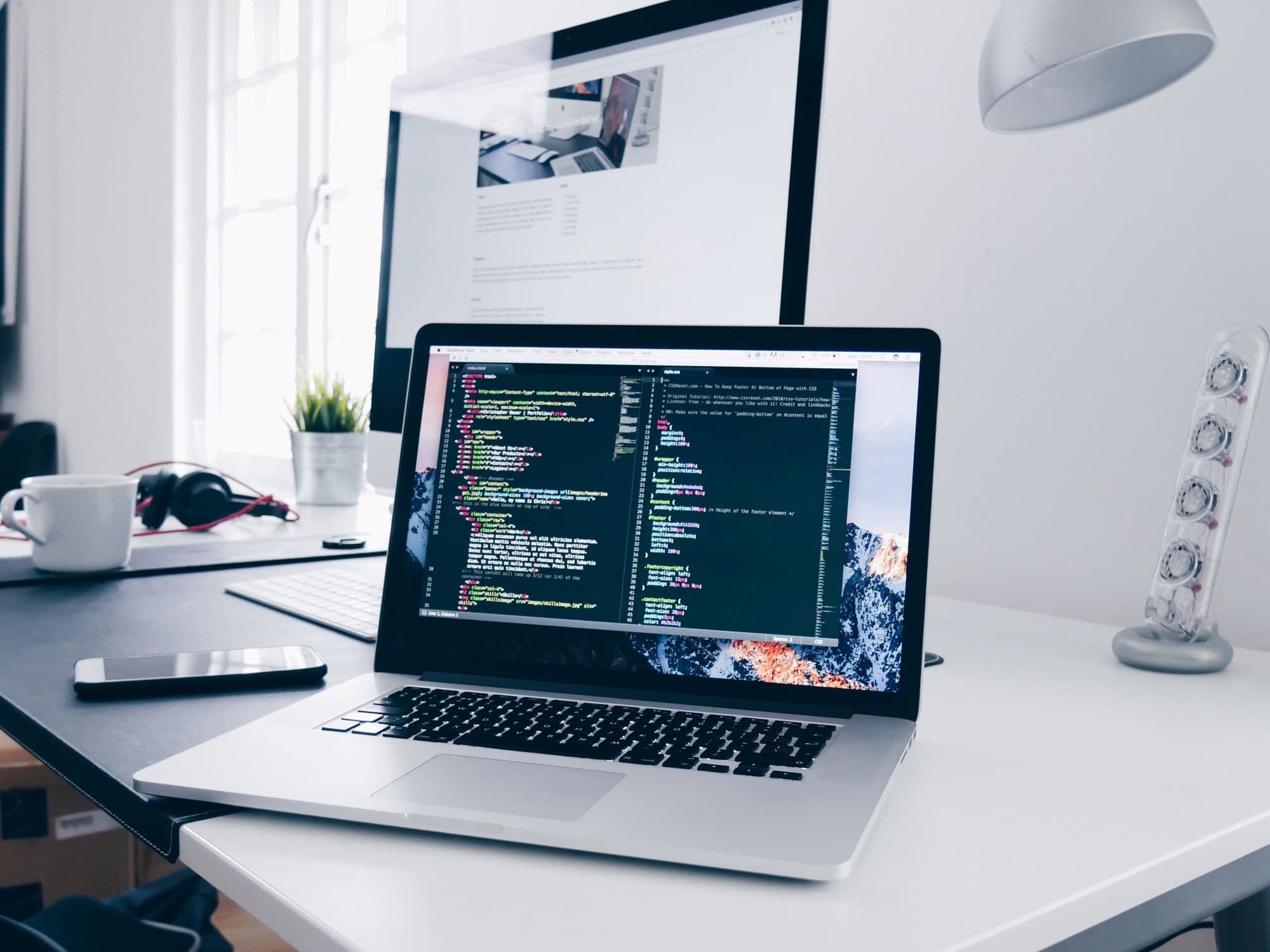 Laptop displaying code editor on desk