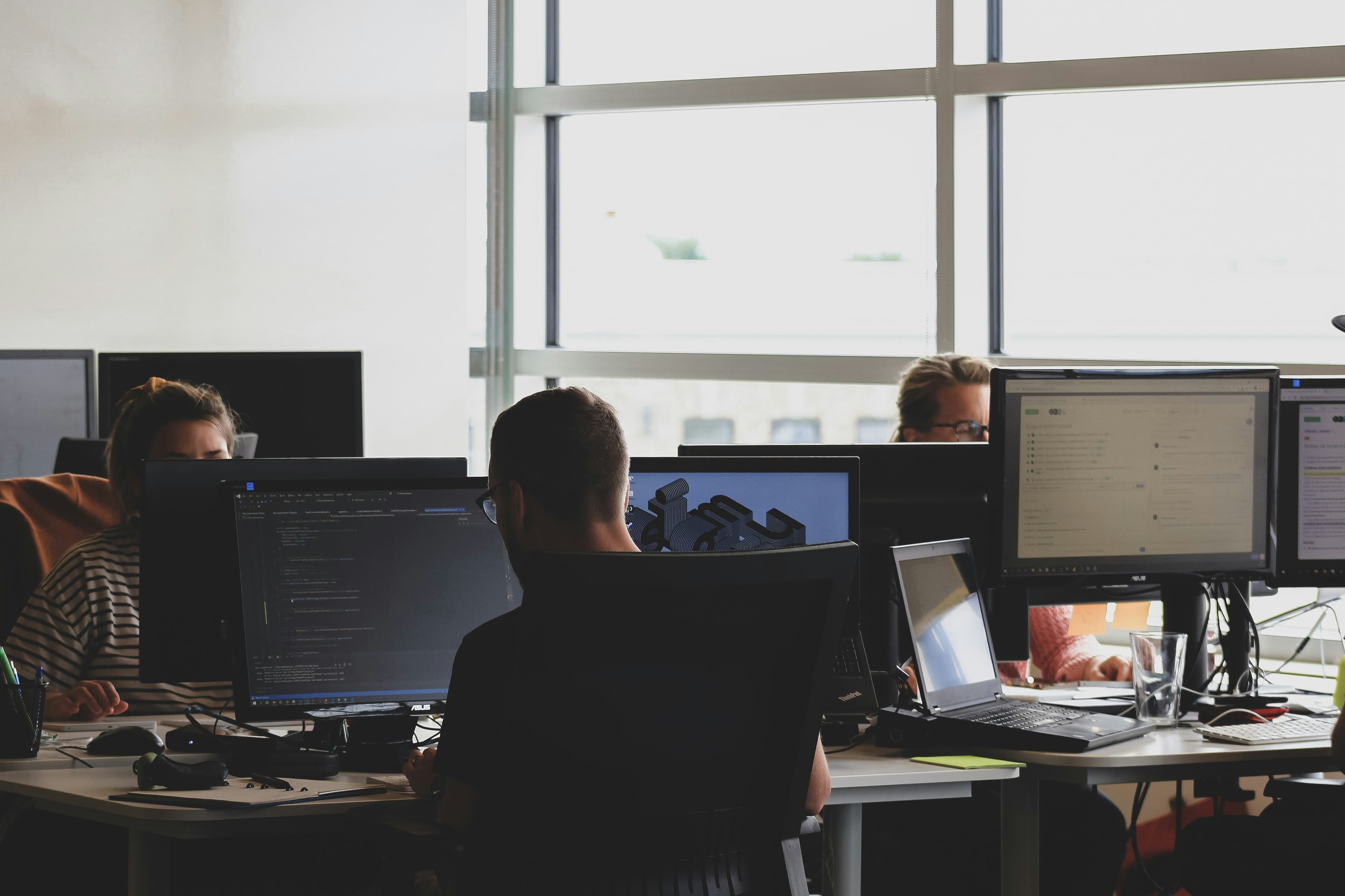 Developers working around a bank of computers in an office